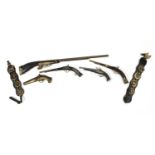Vintage horse brasses on leather straps and decorative guns, the largest 103cm in length : For