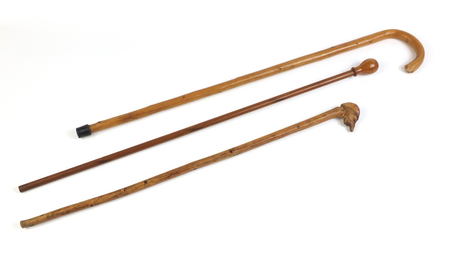 Three wooden walking canes one with carved head handle : For Further Condition Reports Please