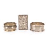 Two circular silver napkin rings and a silver matchbox case, various hallmarks, the largest 4.5cm in