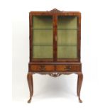 Mahogany display cabinet with a pair of glazed doors enclosing two shelves above two frieze drawers,