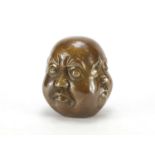 Chinese patinated bronze four sided Buddha head paperweight, character marks to the base, 15cm