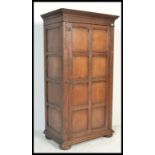 A 19th century Jacobean revival oak armoire - double wardrobe. Raised on large squat bun feet having