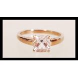 A hallmarked 9ct gold ring set with a cushion cut pink stone. Hallmarked Birmingham. Weight 2.1g.