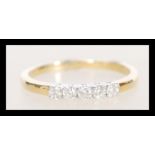 A stamped 18ct gold ring set with five diamonds. Weight 2.3g. Size O.5. Approx 20pts.