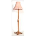A vintage early 20th century Art Deco wooden standard lamp raised on square base with shaped