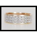 A hallmarked 9ct gold diamond band ring of wide form having three rows of in set diamonds. Weighs