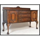 A 1930's Chippendale style mahogany sideboard credenza having a central bank of graduating drawers