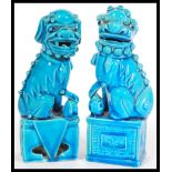 A pair of Oriental Chinese 20th Century ceramic temple lion dogs of Fu in blue raised on square