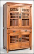 An early 20th century Chinese tall pedestal twin section marriage cabinet. Each section with lattice