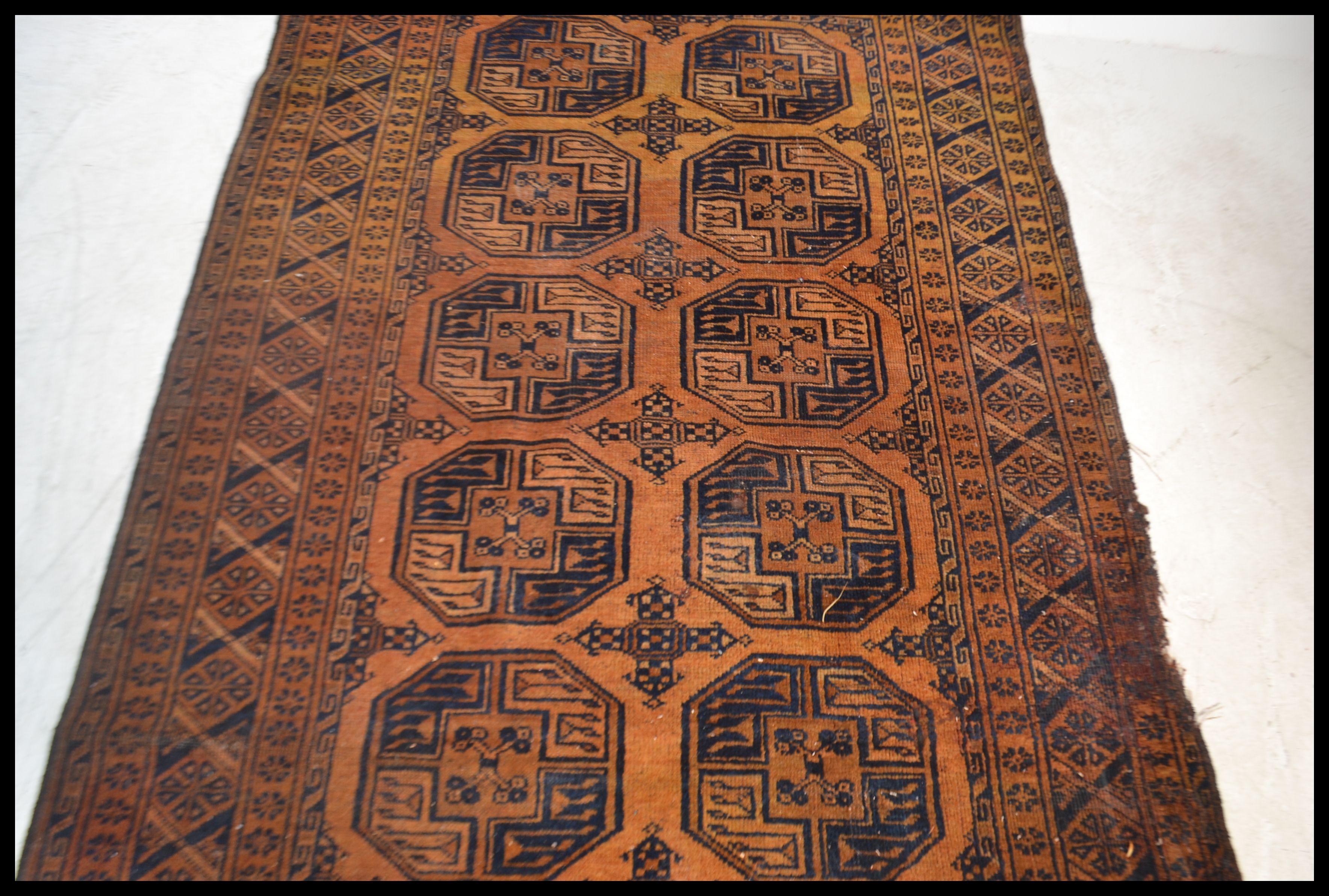 An early 20th century Persian / Islamic Bokhara rug having a red ground with central medallions - Image 2 of 4