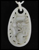 A Chinese hand carved Devil's Work jade necklace and pendant of long form with large panel pendant