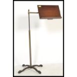 A Victorian mahogany and brass telescopic reading lectern stand being raised on a splayed cast