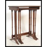 An Edwardian mahogany nest of tables being raised on ring turned legs in the form of bamboo set on