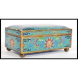 A 20th Century Cloisonne box / casket on a blue ground having red and pink floral decoration on a