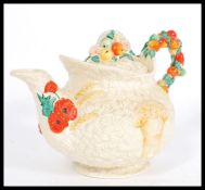 An early 20th century Clarice Cliff ' Celtic Harvest ware' teapot embossed fruit and wheat sheaf