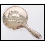 An early 20th Century hallmarked silver mirror having a central bevelled glass circular panel with