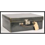 A vintage 20th Century black leatherette suitcase having a metal lock and key and a leather handle