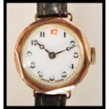 A hallmarked 9ct gold wrist watch having a white enamel face with gilt surrounded chapter ring and