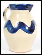 A St Werburgh's Bristol studio pottery jug having a white and blue glaze. Stamped to the base.