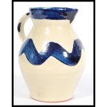 A St Werburgh's Bristol studio pottery jug having a white and blue glaze. Stamped to the base.