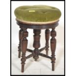 A late 19th / early 20th Century piano stool raised on four turned legs around a central turned