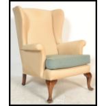 A vintage 20th century retro Parker Knoll wing back armchair raised on wooden pad feet. Measures: