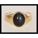A hallmarked 9ct gold signet ring of large form having a deep red agate stone in oval setting.