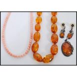 A selection of amber type jewellery to include a beaded necklace, a marked 925 silver pendant set