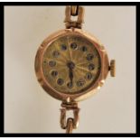 A vintage 20th Century Art Deco 9ct gold ladies wrist watch having a yellow metal face, arabic