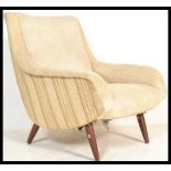 A vintage retro Danish style armchair having curved shaped arm rests on cylindrical beech angled