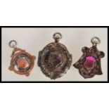 A group of three early 20th Century hallmarked silver pocket watch armorial fob medals - two of