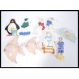 A collection of vintage wall plaques to include graduating angel fish examples, various characters