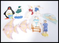 A collection of vintage wall plaques to include graduating angel fish examples, various characters