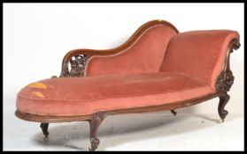 A Victorian 19th century mahogany chaise longue having a scrolled show wood frame with white ceramic