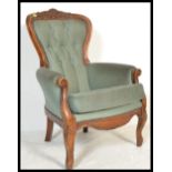 A 20th Century Georgian revival walnut framed fireside spoon back armchair, upholstered with