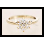 A hallmarked 9ct gold and diamond cluster ring set with seven round cut diamonds. Total approx .