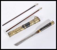 An early 20th century Chinese utensils set contained within a brass and leather sheath decorated
