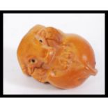 A 20th century Japanese carved wooden netsuke in the form of a bison with signature present.