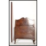 A 1930's mahogany Queen Anne revival mahogany single bed with shaped head and footboard united by