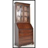 A 20th century mahogany bureau library bookcase being raised on shaped base with a bank of drawers