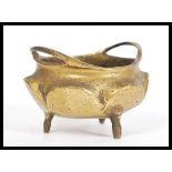 A 19th Century Chinese gilt bronze censer ding bowl raised on tripod feet with hoop handles. Six