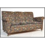 A 1920's Chesterfield 3 seat sofa settee being raised on bun feet with castors having barrel arms