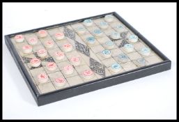 A 20th century Chinese checkers board game having stone counters gaming pieces having calligraphy