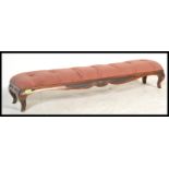 A Victorian 19th century long mahogany footstool being upholstered in a pink velour fabric over a
