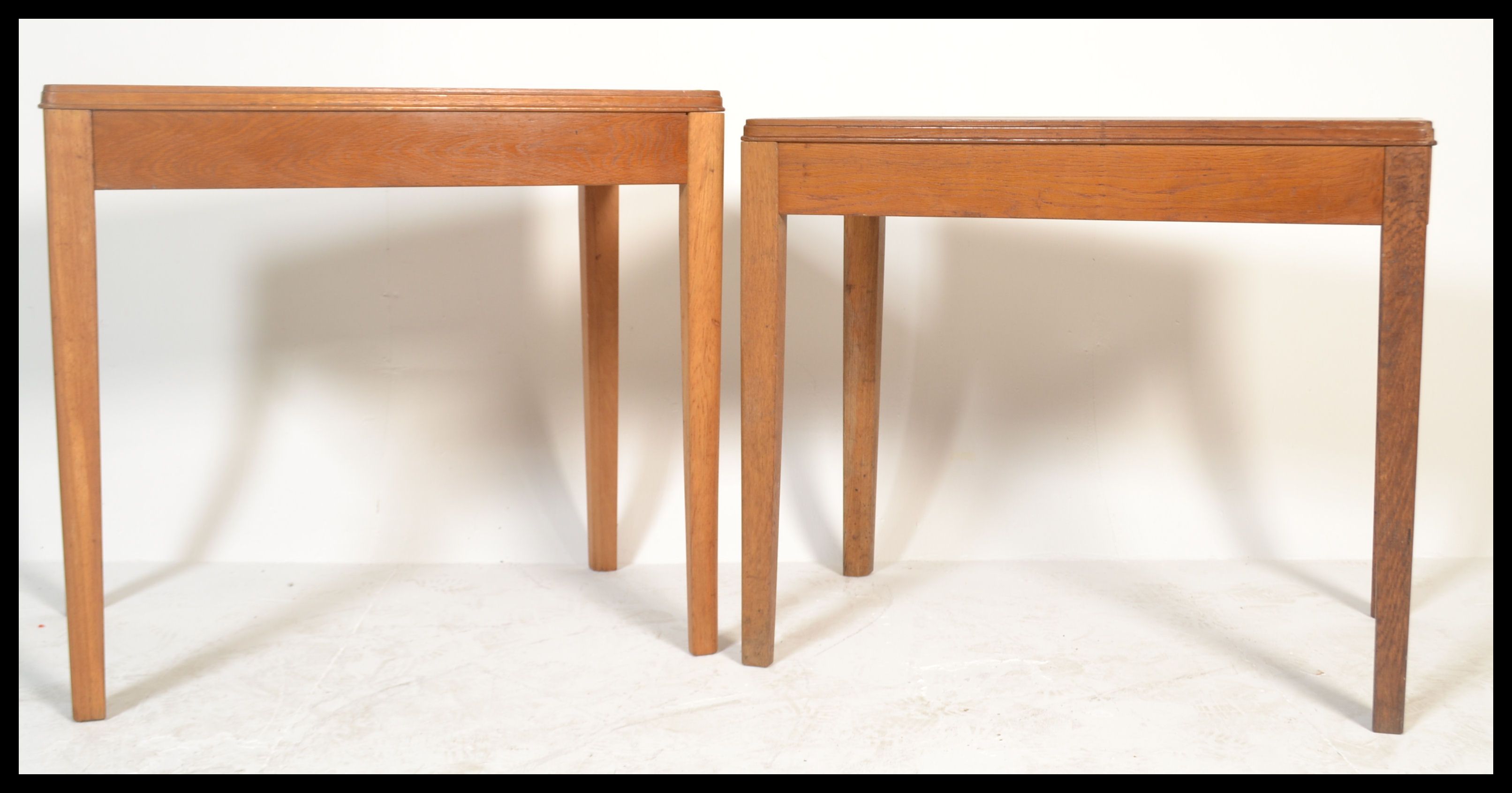 A pair of mid century Air Ministry marked office desks - writing tables in golden oak being raised