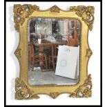 An early 20th century gilt wall mirror of rectangular form having heavy rococo insipiration to