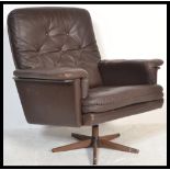 A vintage 1960's / 70's retro Danish swivel armchair upholstered with brown leather, button backed