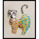A sterling silver plique a jour cat brooch having marcasite decoration with ruby eyes. Weighs 8.7