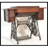 A Victorian oak and cast iron Singer Sewing machine and treadle table. The decorative cast iron