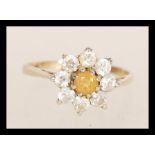 A hallmarked 9ct gold ring set with a central yellow stone flanked by white stones. Hallmarked